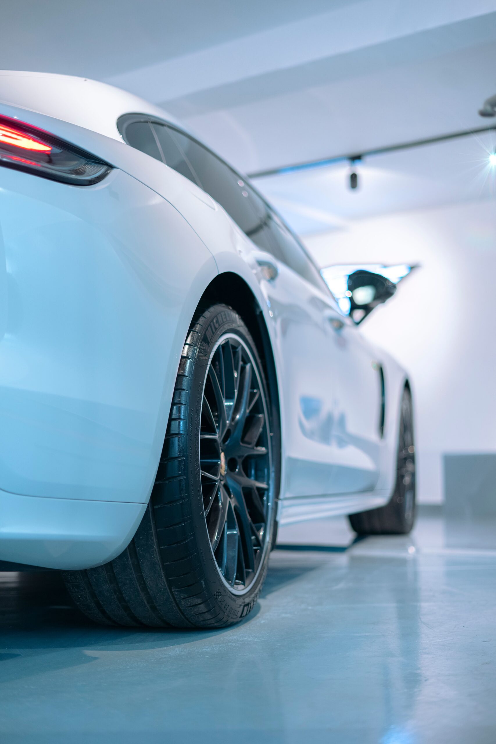 A sleek white sedan parked indoors with modern lighting and design.