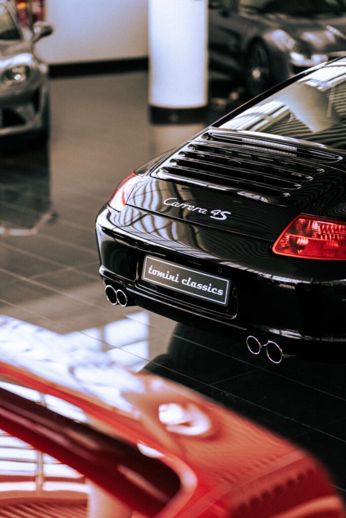Mantén tu Porsche en Perfecto Estado: Guía de Mantenimiento Elegant black Porsche Carrera 4S showcased in a modern showroom setting, highlighting luxury and automotive design.