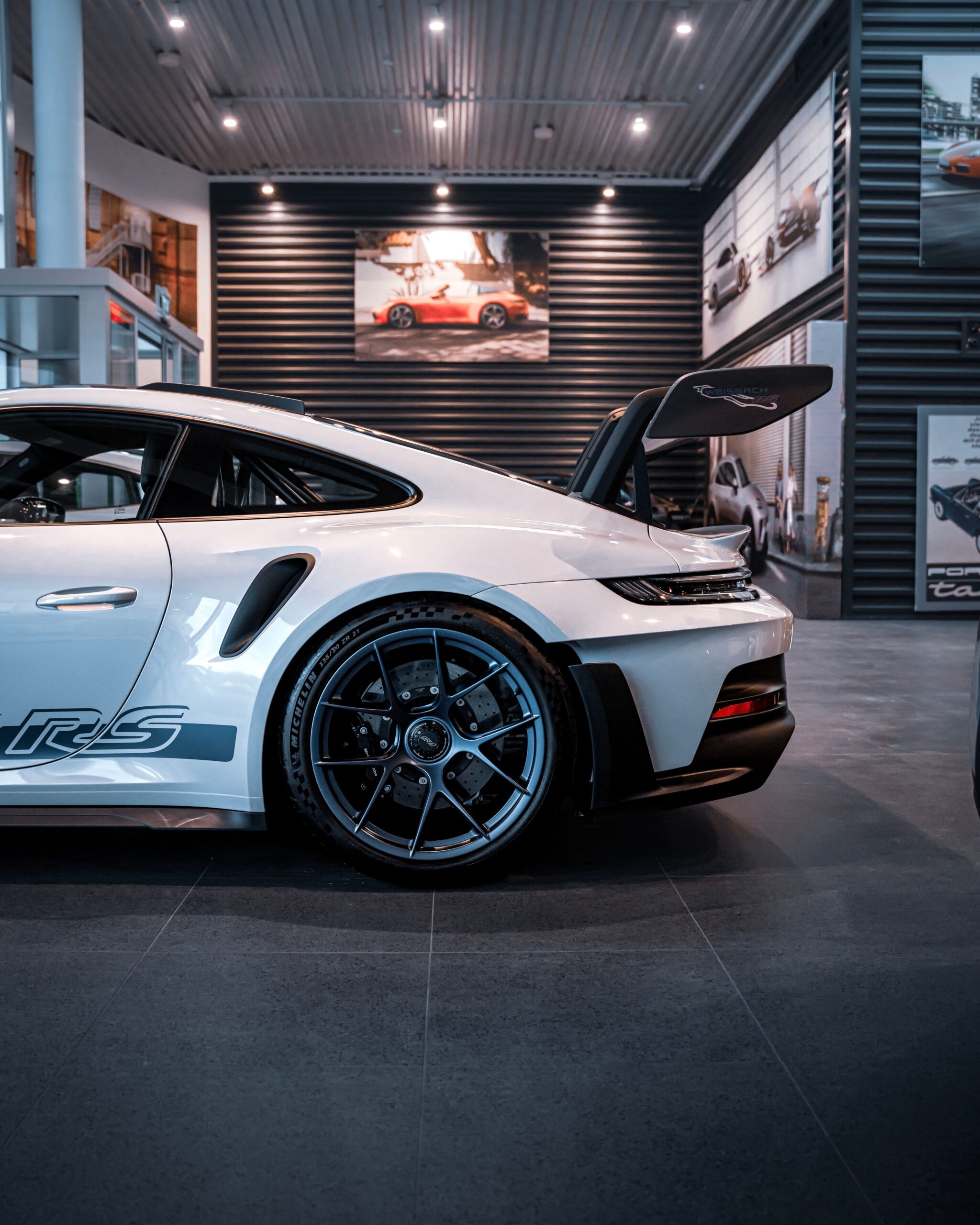 A white sports car displayed elegantly in a modern showroom setting, showcasing luxury automobile design.